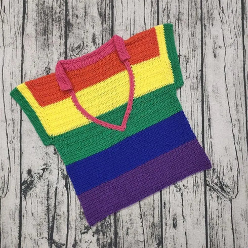 Colorful striped crochet top with pink halter neck, rainbow colors on wooden background