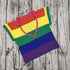 Colorful striped crochet top with pink halter neck, rainbow colors on wooden background