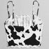Black and white cow print bikini top with spaghetti straps on a plain background