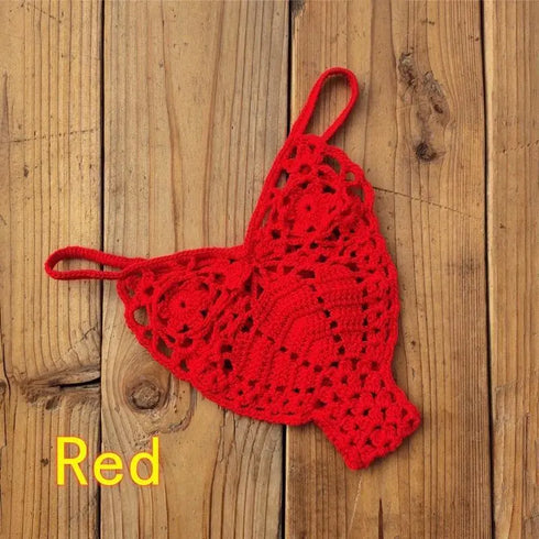 Red crochet bikini top with intricate pattern on wooden background