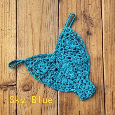 Sky blue crochet bikini bottom with floral pattern on wooden background