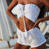 Woman wearing white crochet bikini top and shorts beachwear set