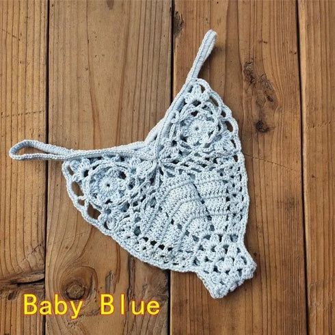 Baby blue crochet bikini thong bottom on wooden background, women's swimwear.