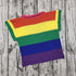 Colorful crochet rainbow striped short sleeve top on wood background