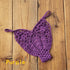 Purple crochet bikini top with floral patterns on wooden background