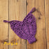 Purple crochet bikini top with floral patterns on wooden background