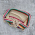 Colorful crochet bikini top with striped pattern and beige lining on a gray background