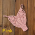 Pink crochet bikini bottom with floral pattern on wooden background