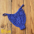 Blue crochet bikini thong bottom with floral pattern on wooden background