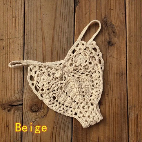 Beige crochet bikini bottom with floral patterns on wooden background