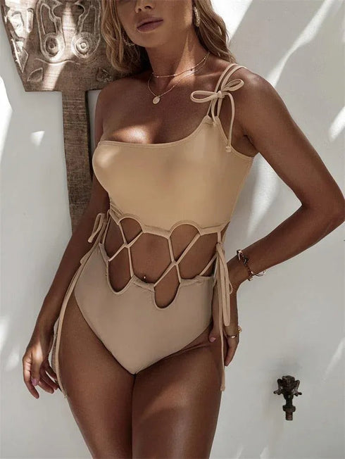 Woman wearing a beige cutout one shoulder bikini monokini with tie side details