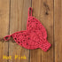 Hot pink crochet bikini thong bottom on wooden surface, trendy swimwear fashion.