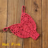 Hot pink crochet bikini thong bottom on wooden surface, trendy swimwear fashion.