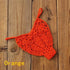 Orange crochet bikini bottom on wooden background, swimwear for women