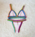 Colorful crochet trim bikini set with triangle top and high-cut bottoms on a soft white background