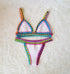 Colorful crochet trim bikini set with triangle top and high-cut bottoms on a soft white background