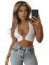 Woman in white bikini halter top with ring detail, light wash jeans, taking mirror selfie