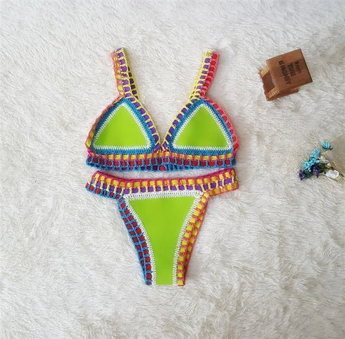 Neon green crochet bikini set with colorful trim, displayed on soft white fabric.
