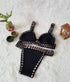 Black crochet bikini set with beige accents on a white fur background, women's swimwear