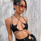Woman wearing a black bikini with red sunglasses against a textured gray background - MiamiTeenyWeenyBikini.Com