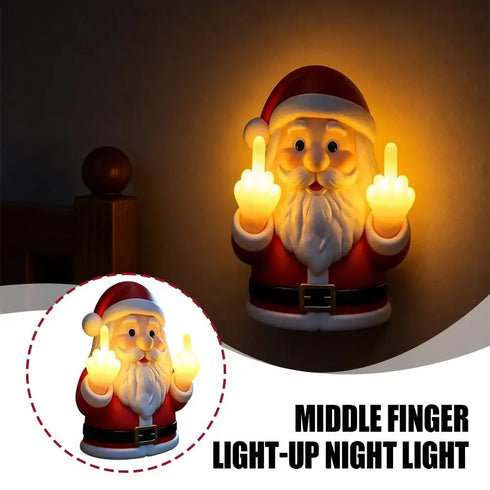 A Santa Claus night light figurine shown glowing in a dark room, with both middle fingers illuminated. A circular inset shows the unlit product, and text at the bottom reads 'MIDDLE FINGER LIGHT-UP NIGHT LIGHT'.
