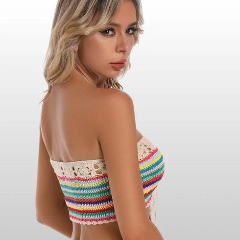 Woman wearing a colorful crochet bikini top, blonde hair, posing against light background