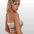 Woman wearing a colorful crochet bikini top, blonde hair, posing against light background