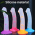 Four silicone toys in different colors with star, heart, and circle patterns on a dark background.